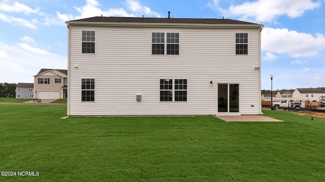 rear view of house with a lawn and a patio area