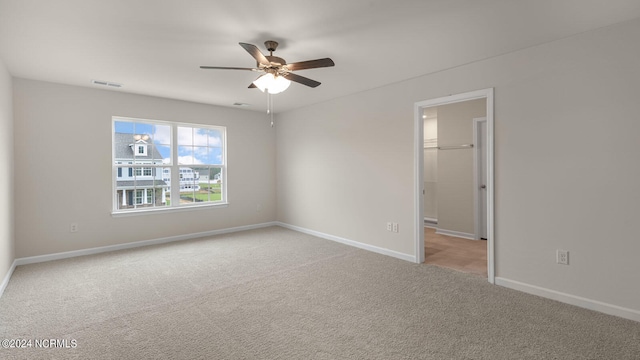 carpeted spare room with ceiling fan