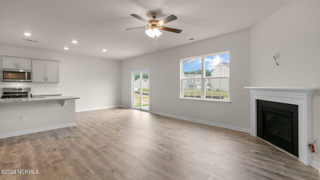 unfurnished living room featuring hardwood / wood-style floors and ceiling fan