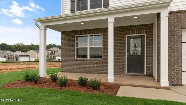 view of exterior entry featuring covered porch