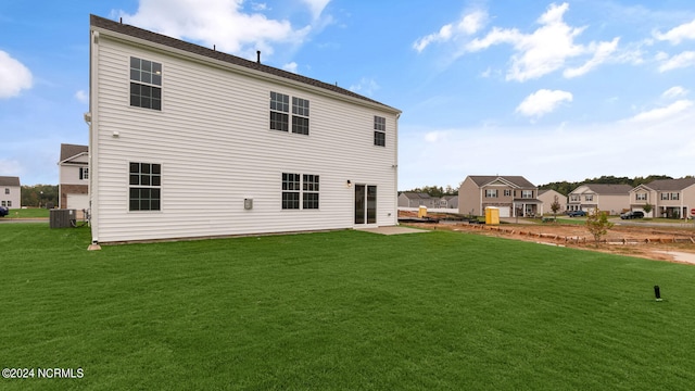 back of property with a lawn, a patio, and central air condition unit