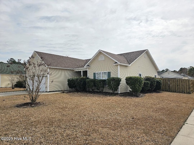 view of home's exterior featuring fence and driveway