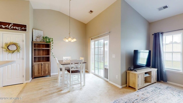 dining room featuring lofted ceiling, an inviting chandelier, light carpet, and visible vents