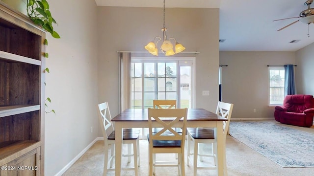 dining space with light colored carpet, visible vents, baseboards, and ceiling fan with notable chandelier