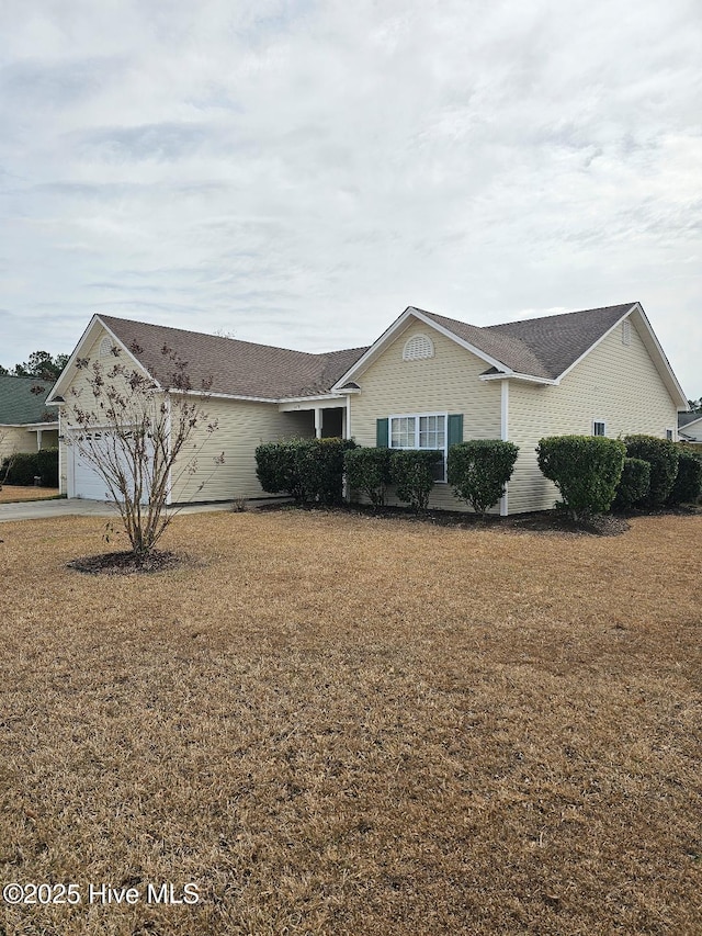 view of front of property featuring a garage and a front lawn