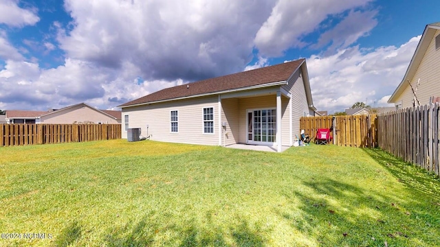 back of property featuring a yard, a fenced backyard, and cooling unit