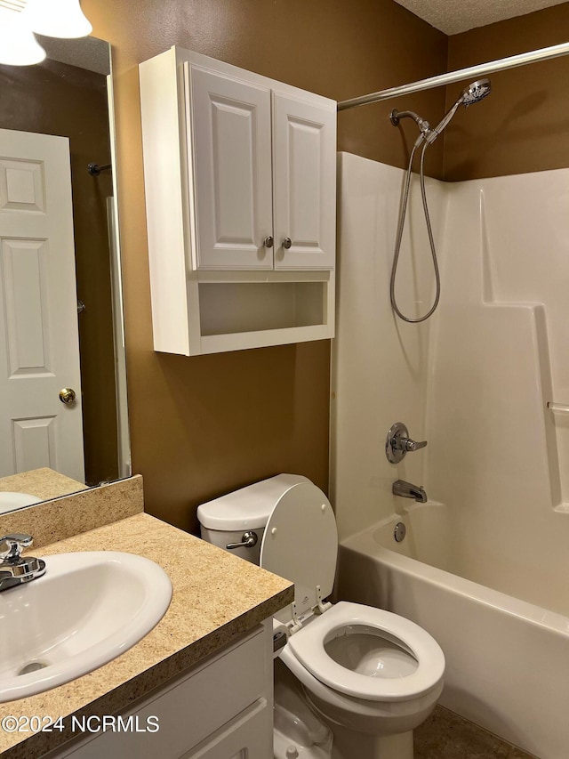 full bathroom featuring a textured ceiling, shower / tub combination, vanity, and toilet