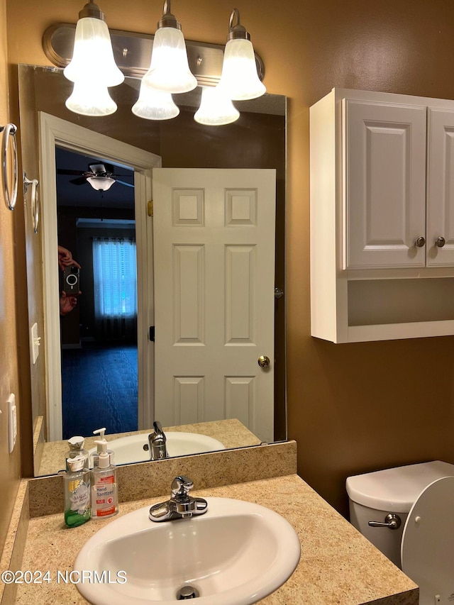 bathroom with ceiling fan, toilet, and sink