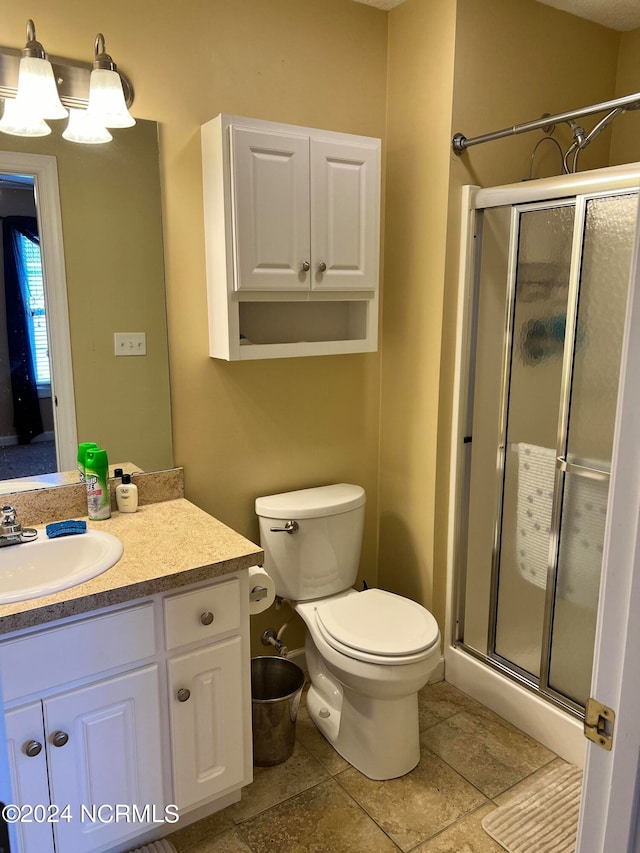 bathroom featuring vanity, toilet, and a shower with door