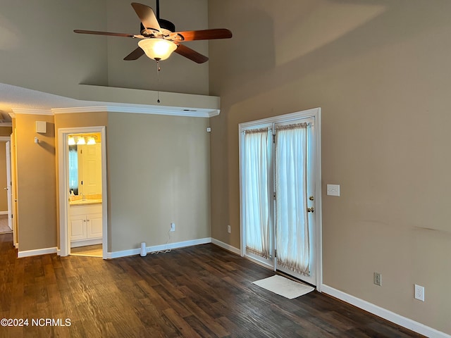 unfurnished room featuring crown molding, a towering ceiling, ceiling fan, and dark wood-type flooring