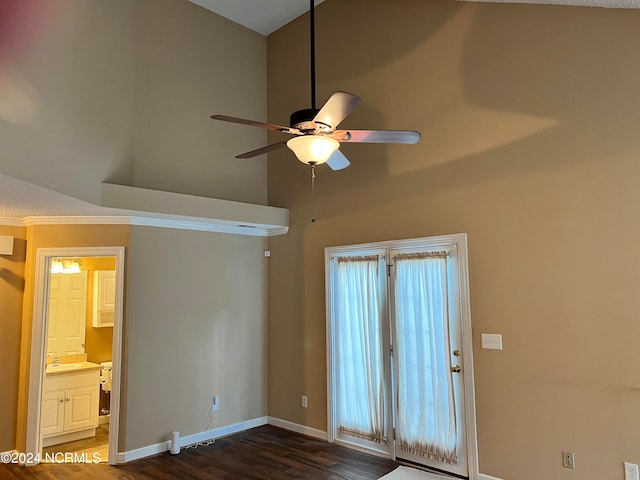 interior space featuring a towering ceiling, ceiling fan, and dark wood-type flooring