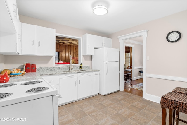 kitchen featuring light stone counters, white cabinets, sink, white appliances, and light hardwood / wood-style floors