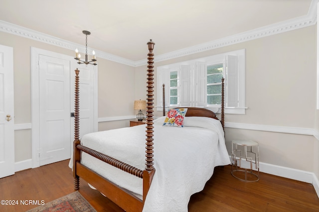 bedroom with wood-type flooring, an inviting chandelier, and crown molding