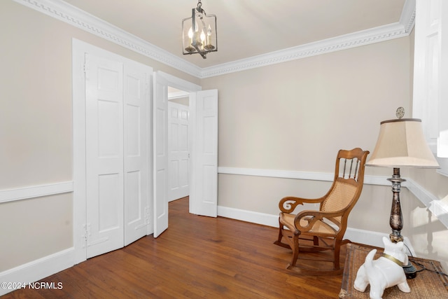 sitting room with a notable chandelier, crown molding, and dark hardwood / wood-style flooring