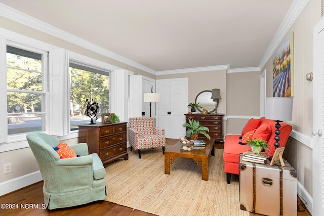 sitting room with ornamental molding and wood-type flooring