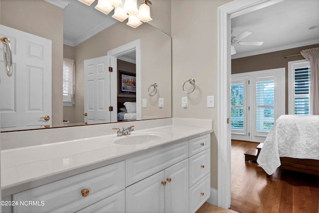 bathroom featuring vanity, crown molding, hardwood / wood-style flooring, and ceiling fan