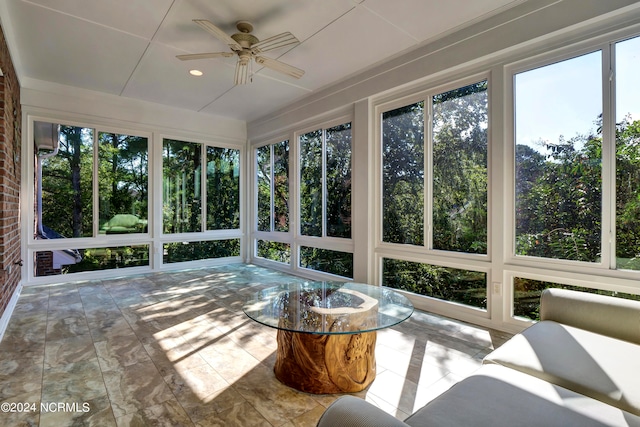 unfurnished sunroom with ceiling fan