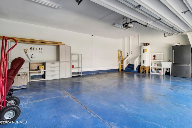 garage with a garage door opener, water heater, and stainless steel refrigerator