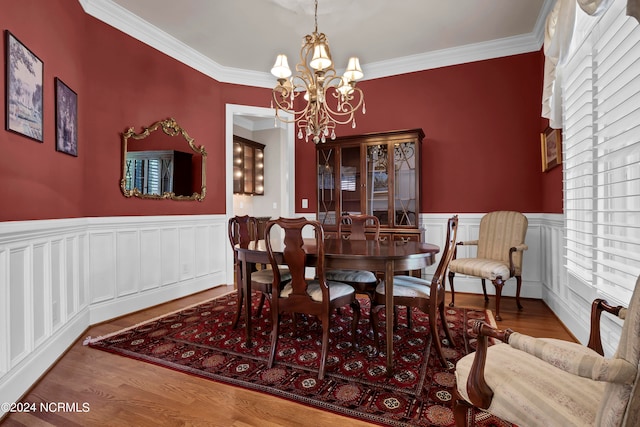 dining room featuring crown molding, a wealth of natural light, an inviting chandelier, and hardwood / wood-style floors