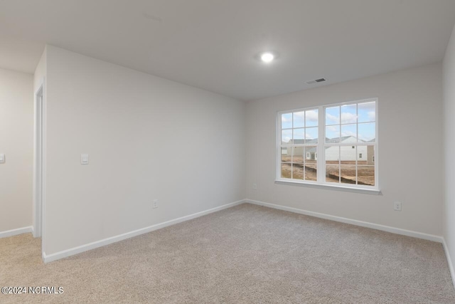 unfurnished room featuring light carpet