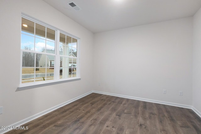 unfurnished room with dark hardwood / wood-style flooring