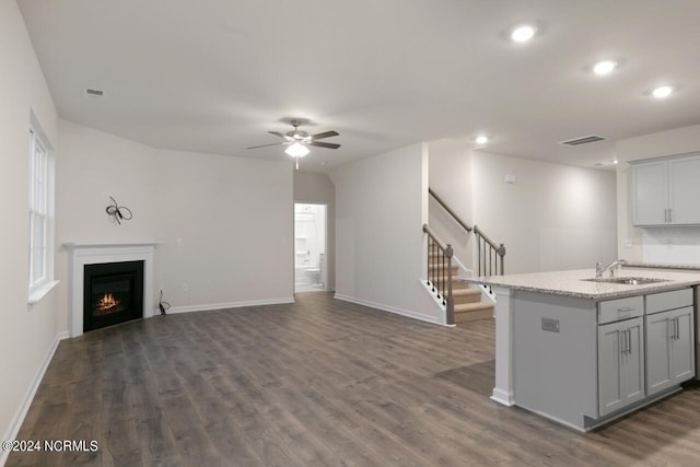 kitchen with dark hardwood / wood-style floors, sink, an island with sink, gray cabinetry, and ceiling fan