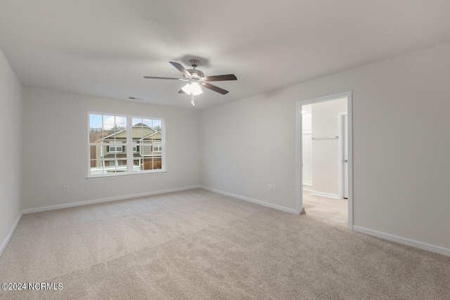 carpeted spare room with ceiling fan