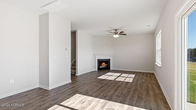 unfurnished living room with ceiling fan and dark wood-type flooring