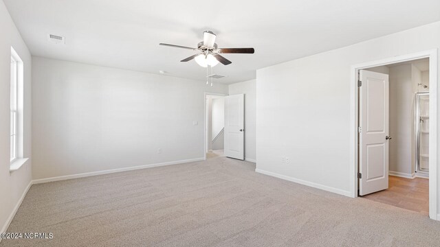 spare room with ceiling fan and light carpet