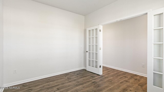 empty room featuring french doors and dark hardwood / wood-style flooring