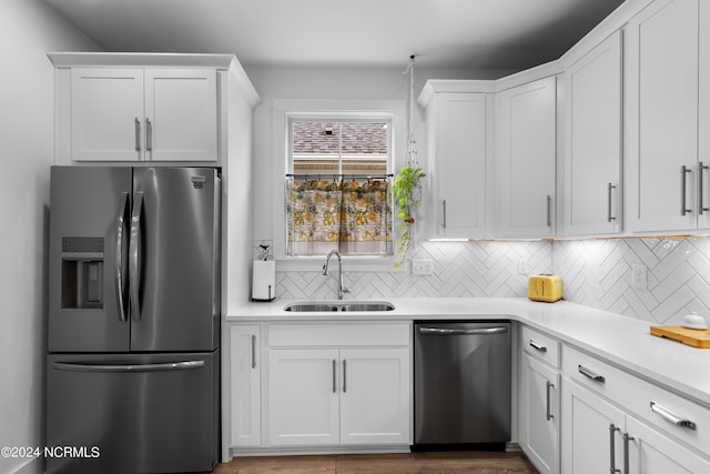 kitchen featuring backsplash, stainless steel appliances, sink, and white cabinets