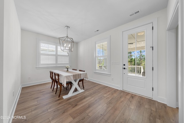 dining space with a notable chandelier and light wood-type flooring