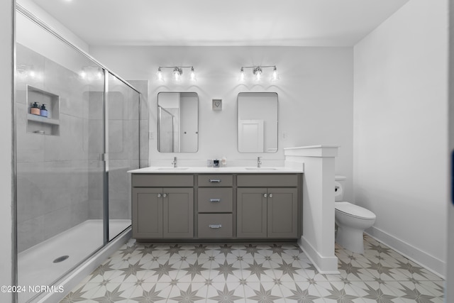 bathroom featuring a shower with door, vanity, and toilet