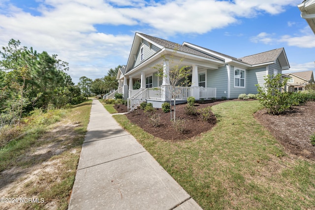 view of side of home featuring a yard and covered porch