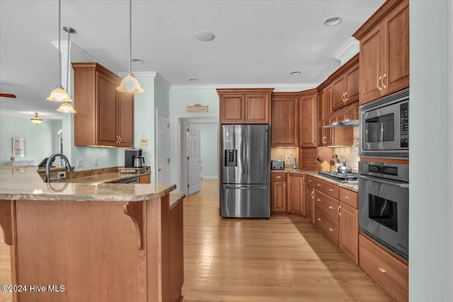 kitchen with stainless steel appliances, a breakfast bar, kitchen peninsula, decorative light fixtures, and light wood-type flooring