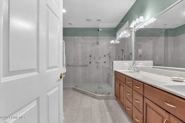 bathroom featuring a shower with door, vanity, and tile patterned floors