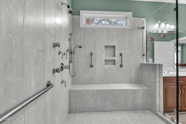 bathroom featuring vanity, tile patterned floors, and a tile shower