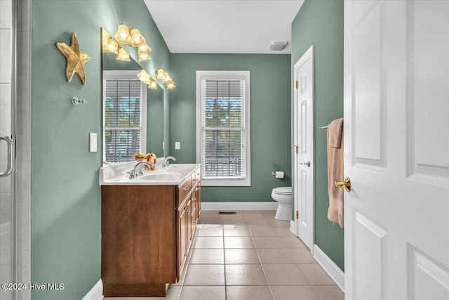 bathroom featuring vanity, tile patterned floors, toilet, and an enclosed shower