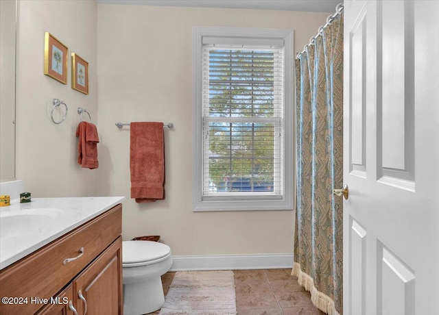 bathroom with toilet, vanity, and tile patterned floors