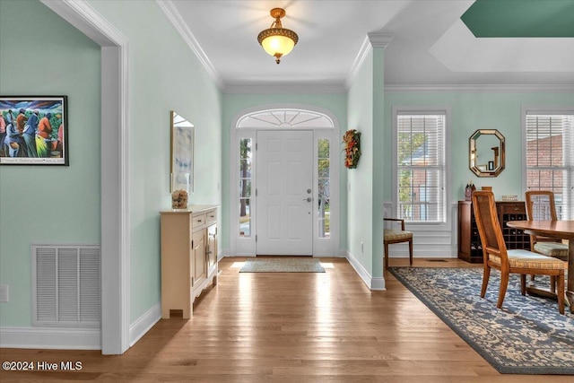 entryway featuring light wood-type flooring and crown molding