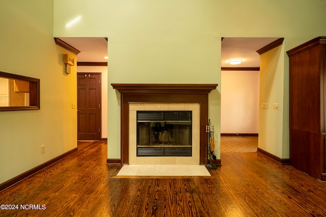 unfurnished living room featuring wood-type flooring, ornamental molding, and a fireplace