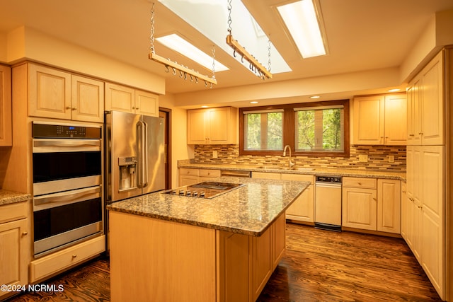 kitchen featuring dark wood-type flooring, stainless steel appliances, backsplash, a center island, and light stone counters