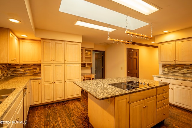 kitchen featuring tasteful backsplash, a center island, dark hardwood / wood-style flooring, light stone counters, and electric cooktop