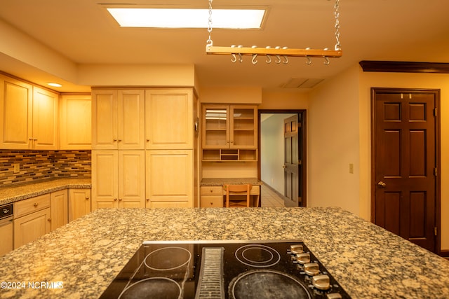 kitchen featuring rail lighting, backsplash, cooktop, light brown cabinetry, and light stone counters