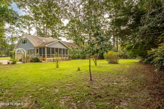 view of yard with a garage and a sunroom