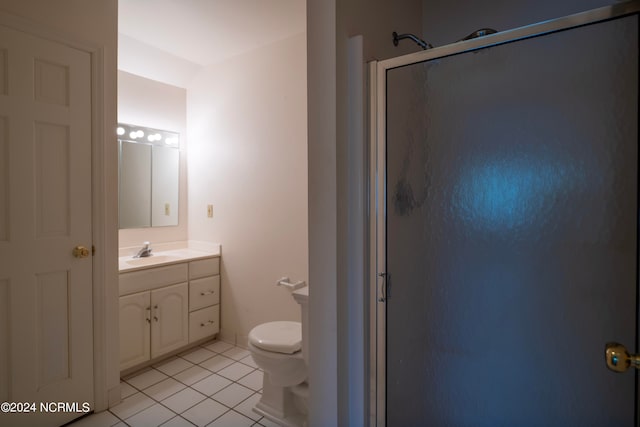 bathroom with vanity, tile patterned flooring, toilet, and walk in shower