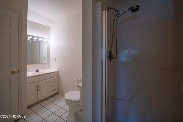 bathroom with vanity, a shower, toilet, and tile patterned floors