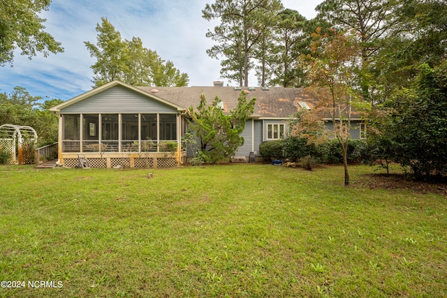 back of property with a lawn and a sunroom