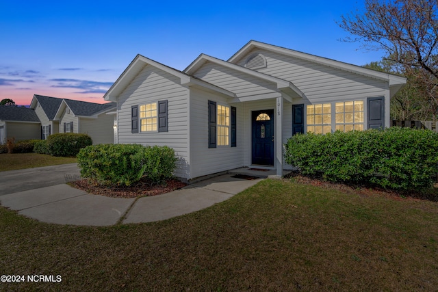 ranch-style home featuring a lawn