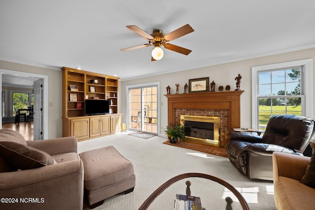 living room featuring a brick fireplace, crown molding, and a wealth of natural light